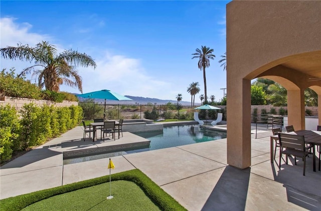 view of pool featuring a mountain view, an in ground hot tub, and a patio