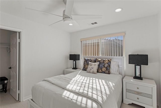 bedroom featuring a walk in closet, a closet, and ceiling fan