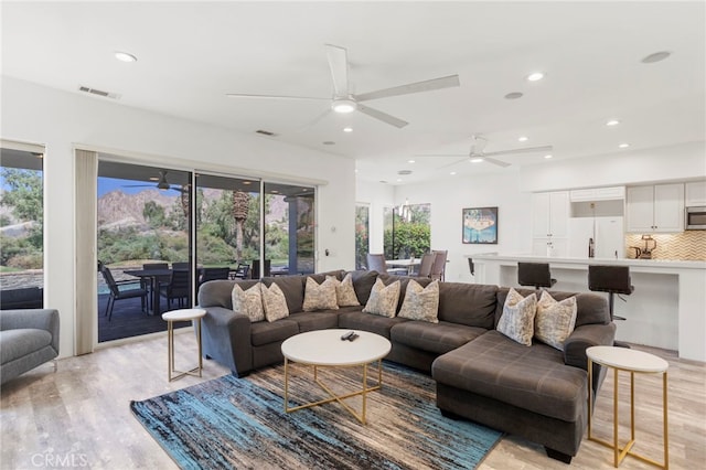 living room featuring ceiling fan, a healthy amount of sunlight, and light hardwood / wood-style floors