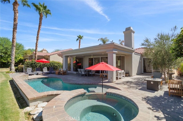 view of pool with an in ground hot tub and a patio