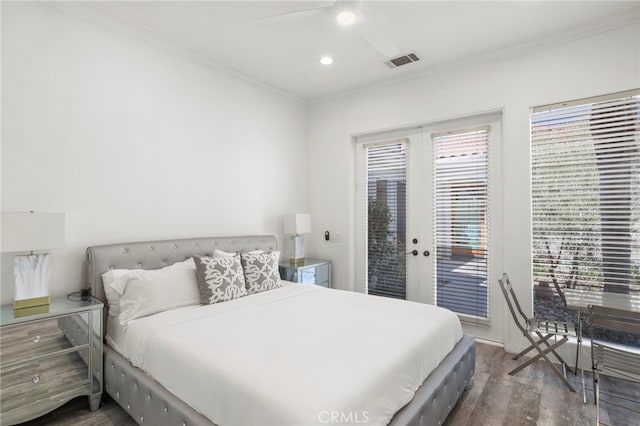 bedroom featuring ceiling fan, dark hardwood / wood-style flooring, access to outside, and multiple windows