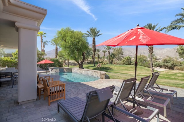 view of swimming pool featuring a lawn, an in ground hot tub, a mountain view, and a patio