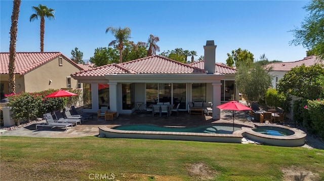 rear view of property with a patio area, a swimming pool with hot tub, and a yard