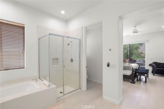 bathroom featuring hardwood / wood-style floors, ceiling fan, separate shower and tub, and toilet