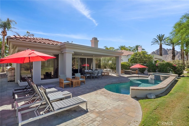 exterior space with an outdoor living space, an in ground hot tub, and a patio