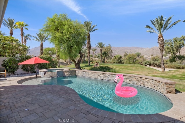 view of pool with a mountain view, a yard, and an in ground hot tub