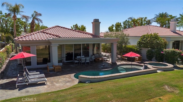 back of house featuring a pool with hot tub, a yard, and a patio