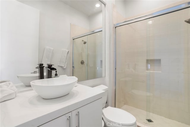 bathroom featuring toilet, vanity, and walk in shower