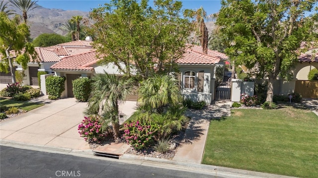 mediterranean / spanish-style home with a mountain view and a front lawn