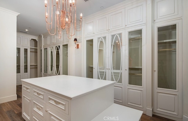 walk in closet featuring a chandelier and dark hardwood / wood-style flooring