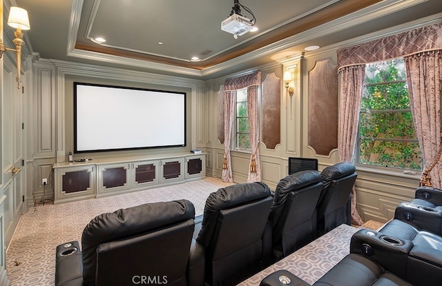 home theater room with crown molding, carpet flooring, plenty of natural light, and a raised ceiling