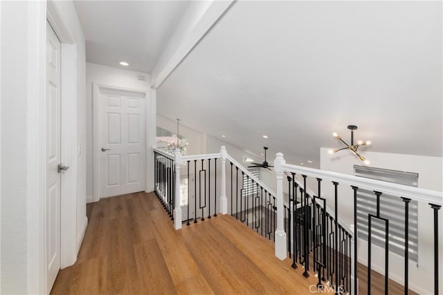 corridor with recessed lighting, an upstairs landing, a chandelier, and wood finished floors