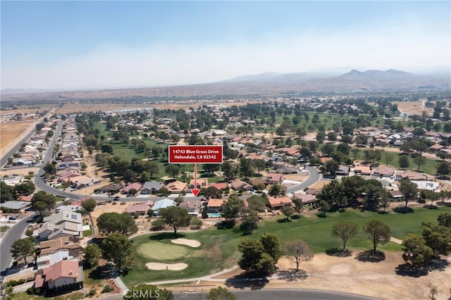 aerial view featuring a mountain view, view of golf course, and a residential view