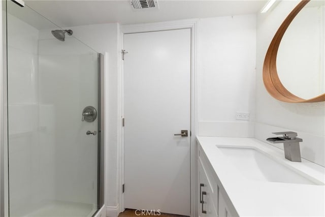 bathroom featuring a stall shower, visible vents, and vanity