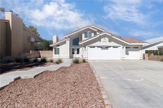 view of front of property with a garage and a wall mounted air conditioner