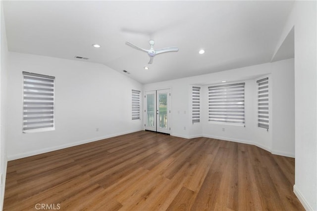 unfurnished room featuring vaulted ceiling, baseboards, ceiling fan, visible vents, and wood finished floors