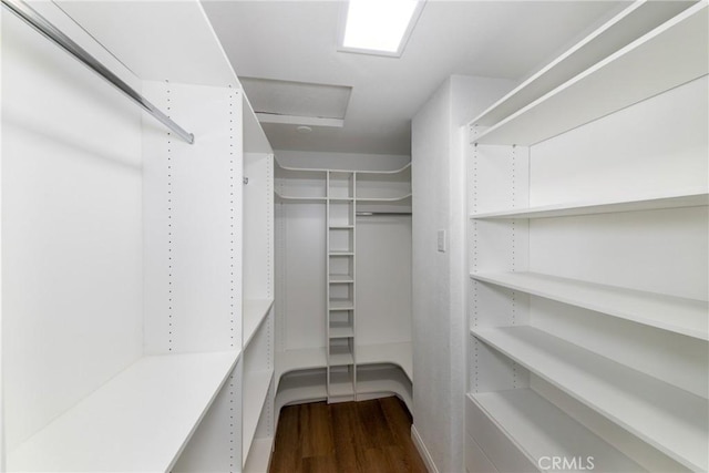 spacious closet with wood finished floors and attic access