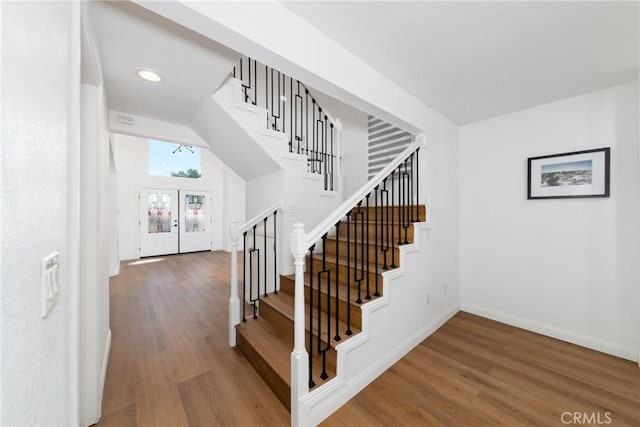 stairway featuring baseboards, wood finished floors, and recessed lighting
