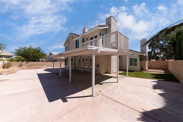 rear view of property with a balcony and a patio