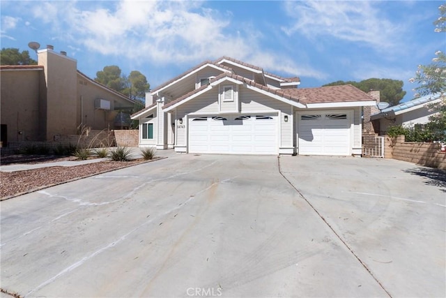 view of front of property featuring a tile roof, an attached garage, and concrete driveway