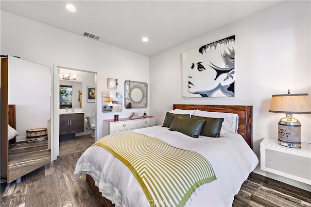 bedroom featuring dark hardwood / wood-style floors and ensuite bath