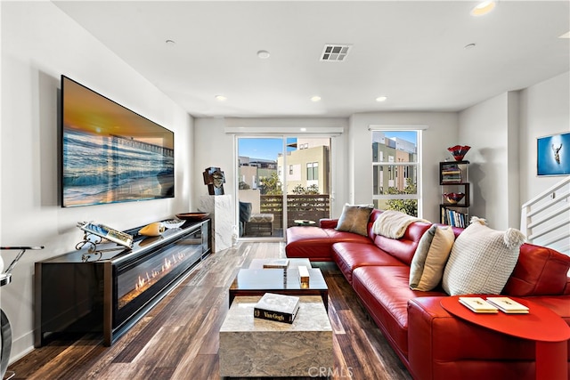 living room with plenty of natural light and dark hardwood / wood-style flooring