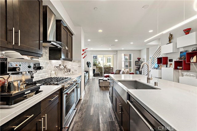 kitchen with sink, dark brown cabinets, wall chimney exhaust hood, stainless steel appliances, and dark hardwood / wood-style floors