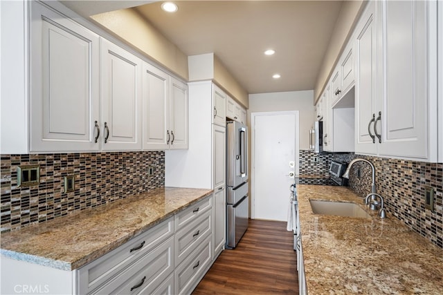 kitchen featuring light stone counters, dark wood-type flooring, sink, white cabinetry, and stainless steel appliances