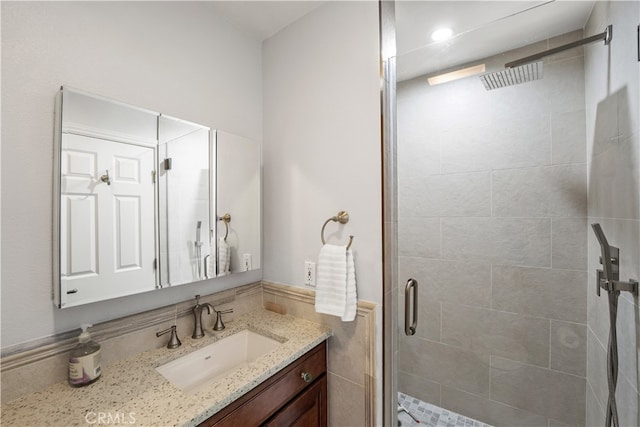 bathroom with vanity and a shower with door