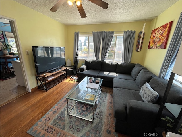 living room featuring a textured ceiling, hardwood / wood-style floors, and ceiling fan