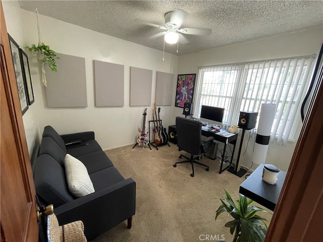 carpeted office space with ceiling fan and a textured ceiling