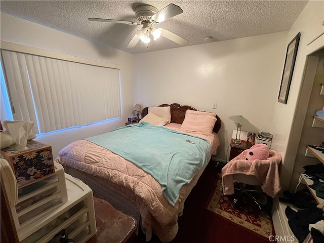 bedroom with ceiling fan and a textured ceiling