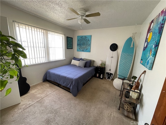 carpeted bedroom featuring ceiling fan and a textured ceiling