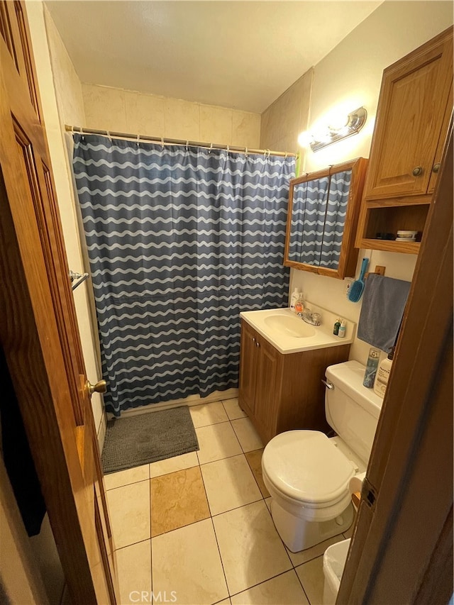 bathroom with a shower with curtain, vanity, toilet, and tile patterned floors