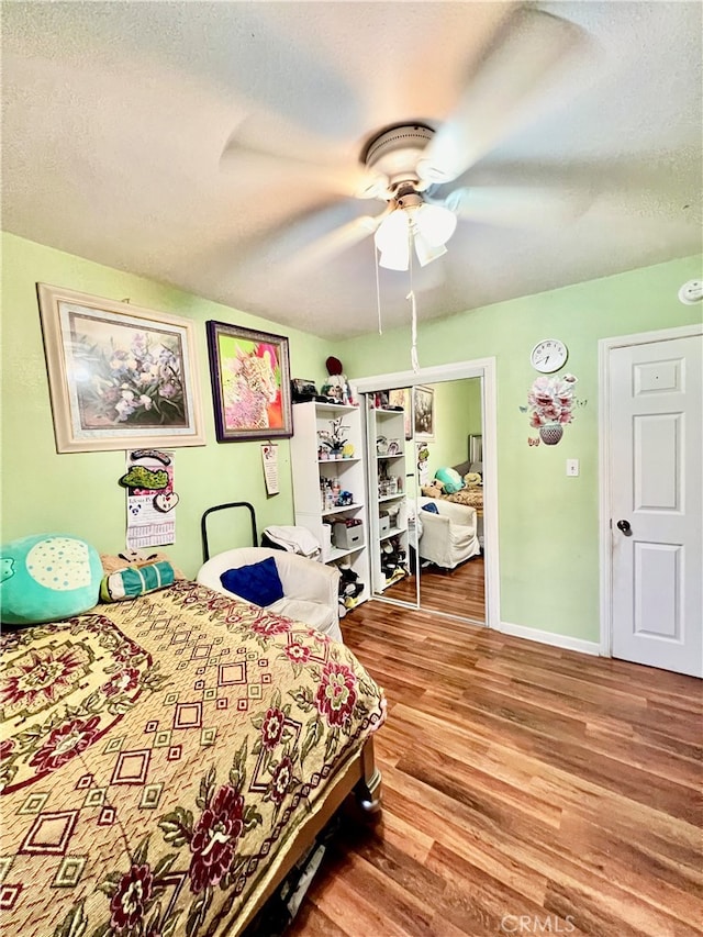 bedroom featuring ceiling fan, a textured ceiling, and wood-type flooring