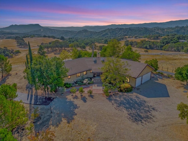 aerial view at dusk featuring a mountain view