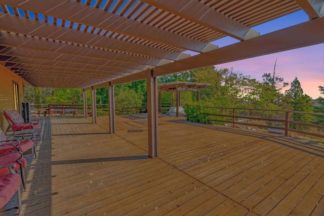 deck at dusk featuring a pergola