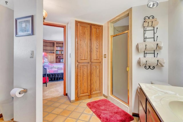 bathroom with tile patterned flooring, vanity, and a shower with door