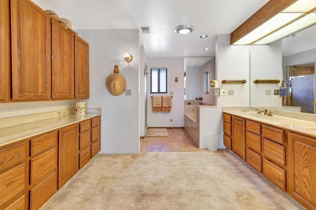 bathroom with tile patterned flooring, a bathtub, and vanity