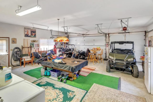 garage featuring white fridge and a garage door opener