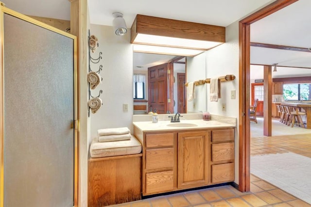 bathroom featuring a shower with door, vanity, and tile patterned flooring