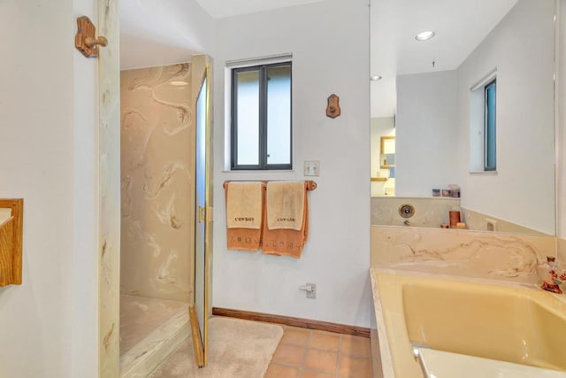 bathroom featuring tile patterned flooring, sink, and a tub to relax in