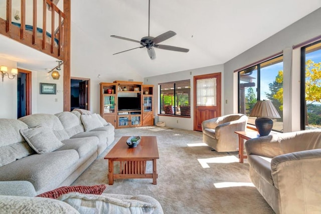 carpeted living room featuring high vaulted ceiling and ceiling fan with notable chandelier