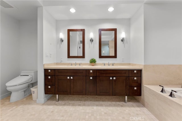 bathroom with tiled bath, vanity, toilet, and tile patterned flooring