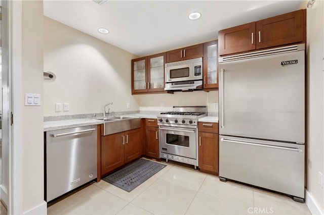 kitchen featuring light tile patterned floors, premium appliances, sink, and ventilation hood