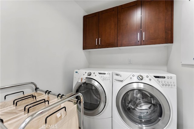 washroom with separate washer and dryer and cabinets