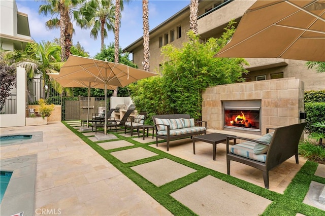 view of patio / terrace featuring an outdoor living space with a fireplace and a swimming pool