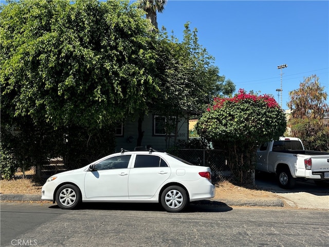 view of property hidden behind natural elements with fence