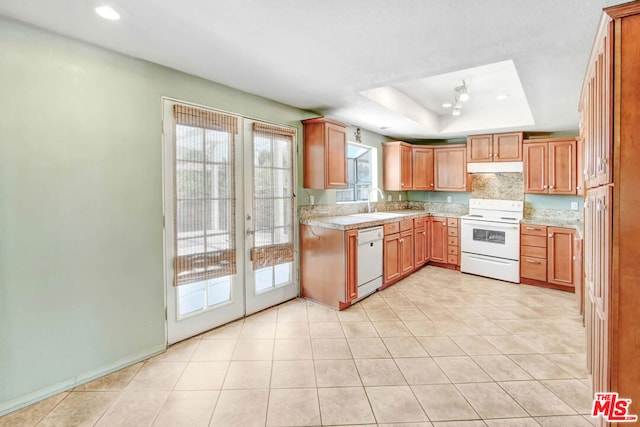 kitchen with french doors, sink, white appliances, a tray ceiling, and light tile patterned floors