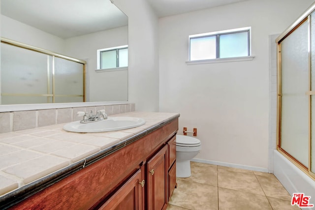 full bathroom featuring tile patterned flooring, vanity, bath / shower combo with glass door, and toilet